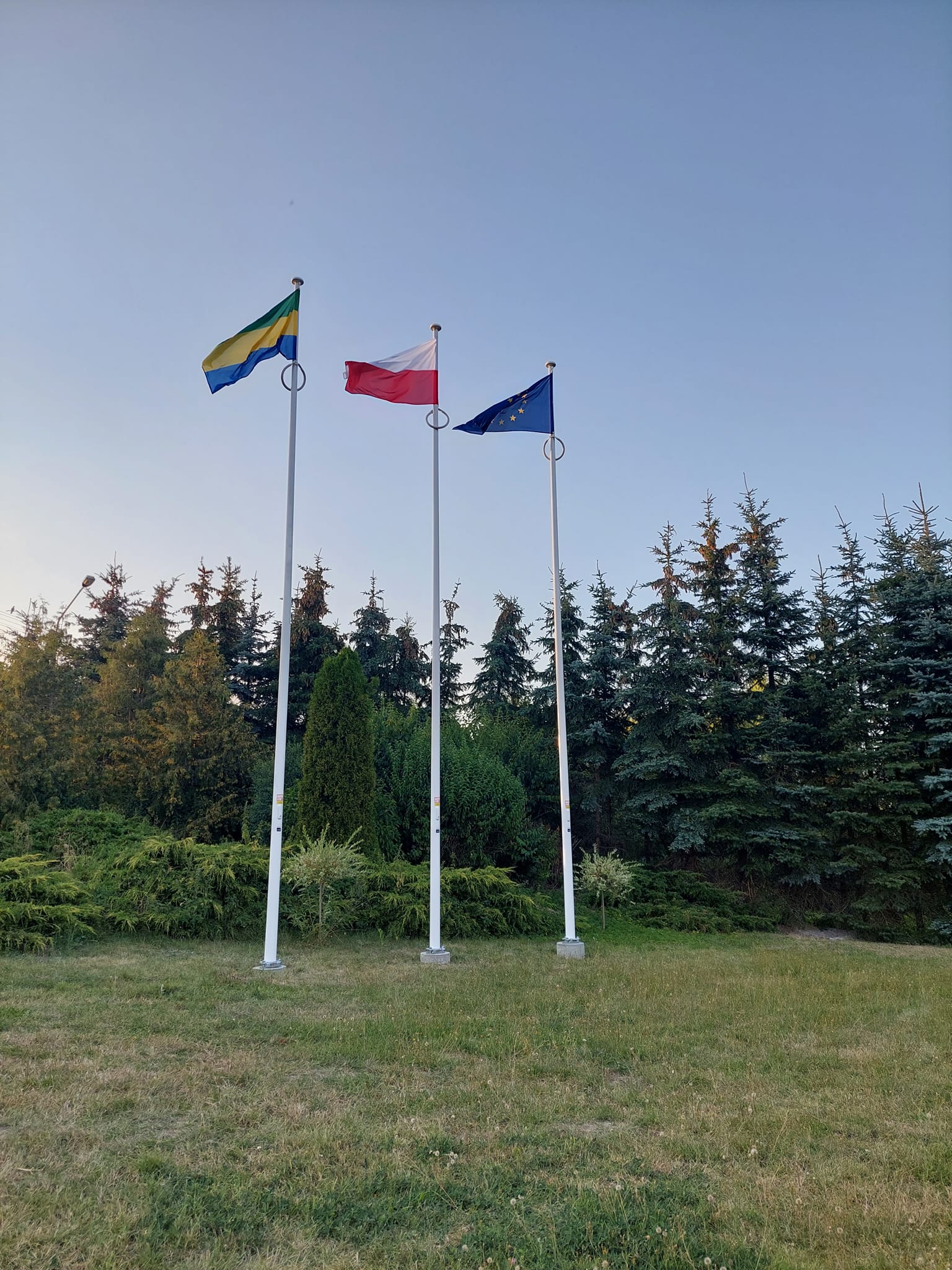 Trzy maszty z flagami: Państwową Rzeczypospolitej Polskiej, Unii Europejskiej oraz Gminy Chojnice